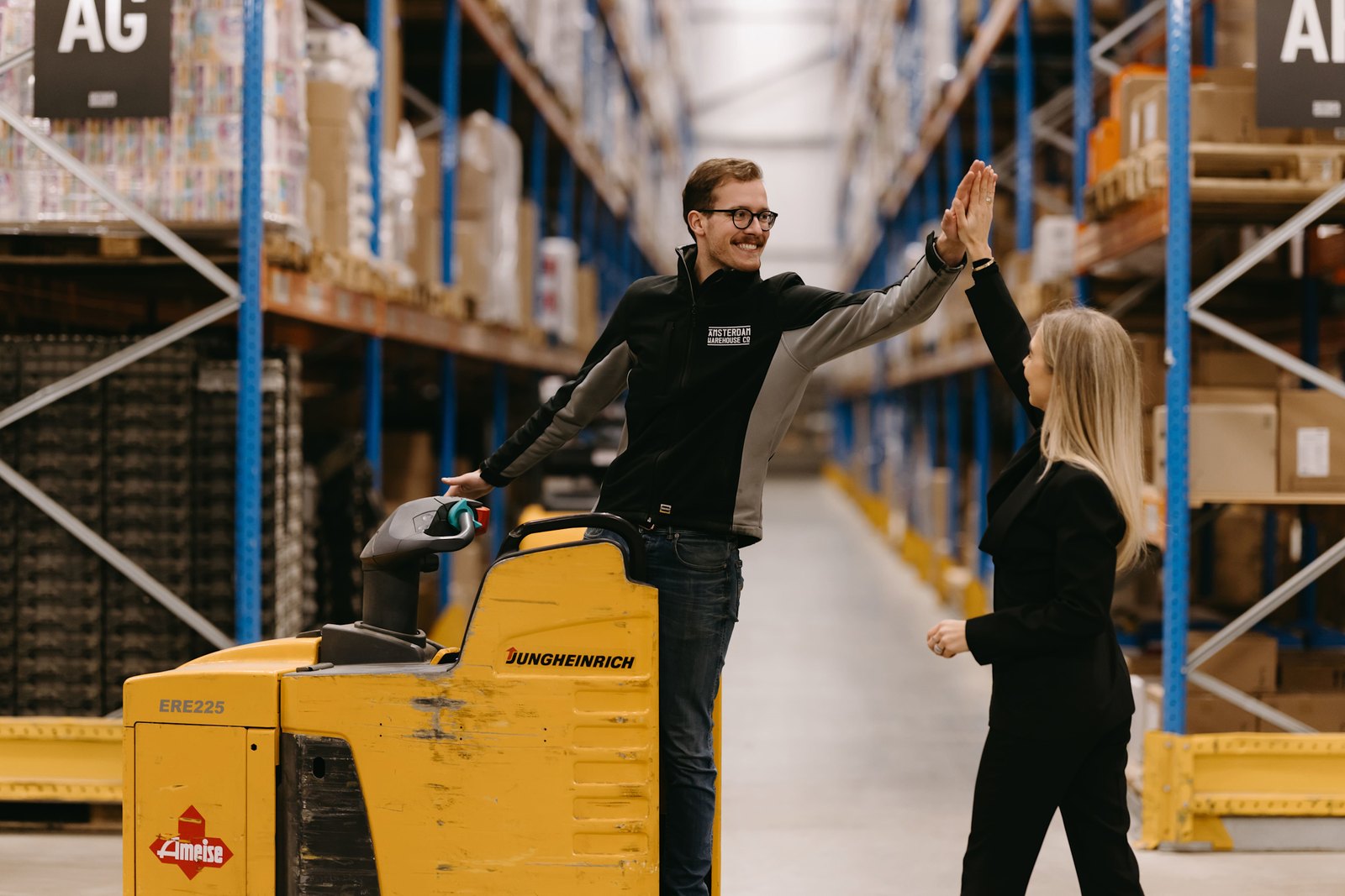Medewerkers van AES International in het magazijn bij een elektrische palletwagen